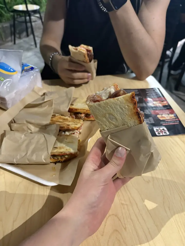 Porciones de pizza envueltas en papel, listas para comer